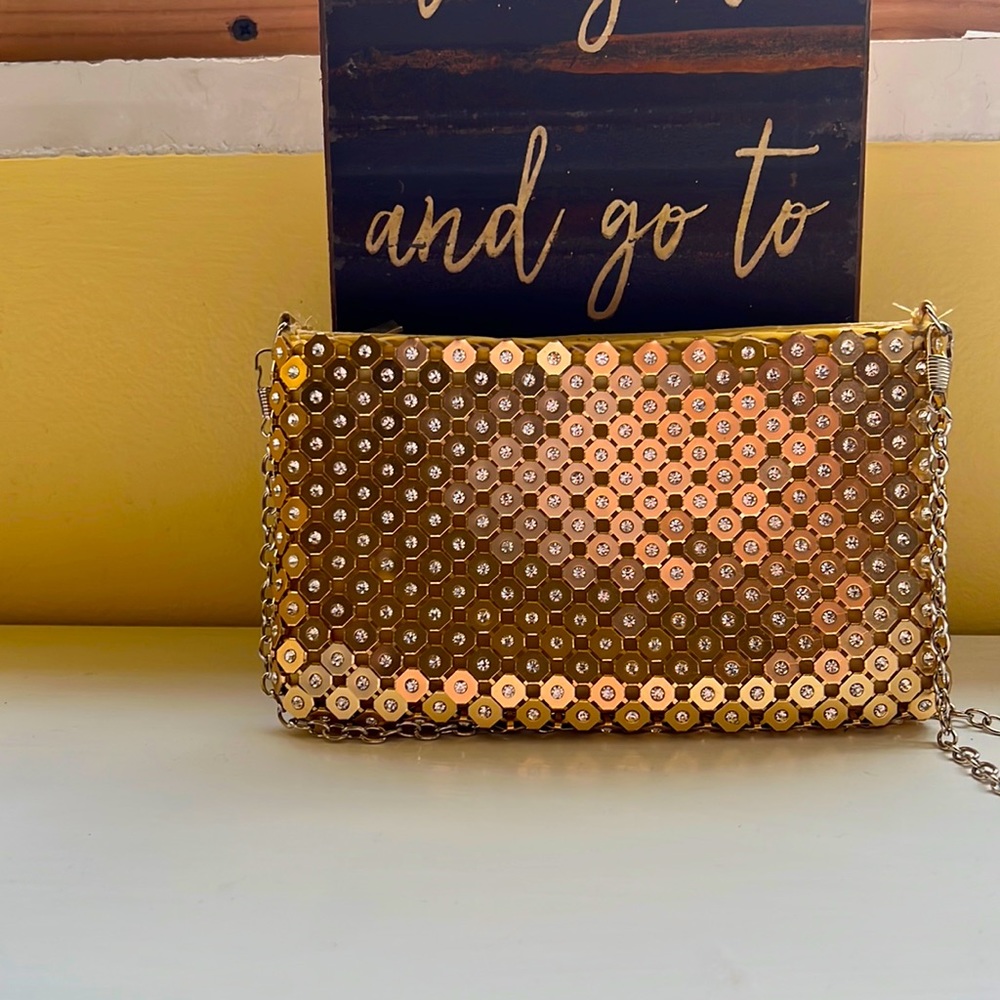 Gold sequined clutch with detachable strap.